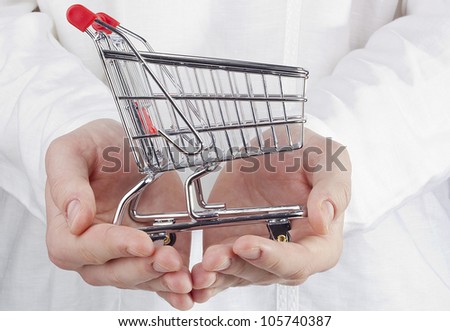 Close-up photograph of man's hands holding a shopping cart.