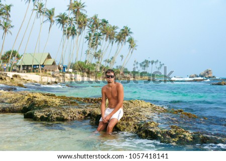  A guy ,walking along the beautiful tropical beach of Sri Lanka. Indian Ocean. The concept of vacation.