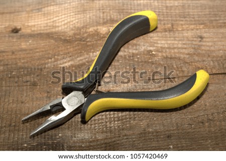 Pliers "platypuses" with isolated handles on a wooden background close-up