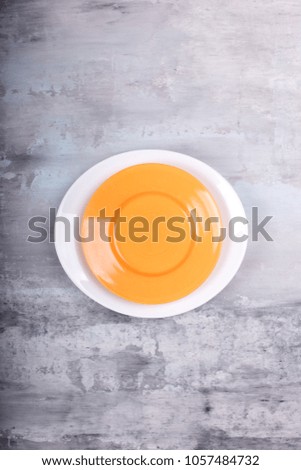 empty yellow and white plate above over gray texture background. plate top view. copy space .