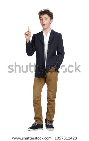 Full length picture of a boy pointing to the copy space area with comic expression