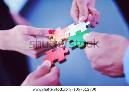 Group of business people assembling jigsaw puzzle and represent team support and help concept Royalty-Free Stock Photo #1057512938