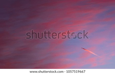 Airplane against the background of red clouds