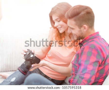 happy young couple checks photos on photos the camera