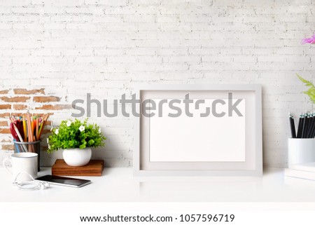Mock up white poster on desk space and vintage white brick wall background.