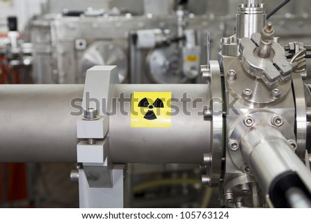 View of important electronic and mechanical parts of ION Accelerator, with high radiation sign, CNC machined parts Royalty-Free Stock Photo #105763124