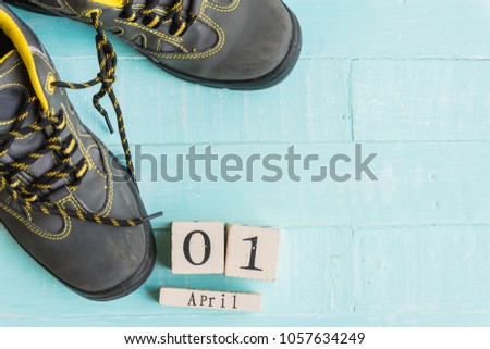April fool's day concept. shoelaces tied together and Wooden block calendar with empty space for text on bright blue and white wooden background.