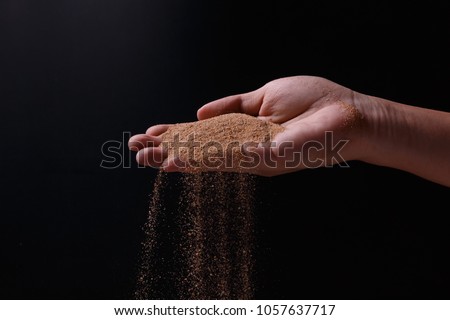 sand explosion with right hand on black background Royalty-Free Stock Photo #1057637717