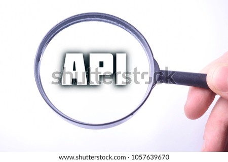 Businessman looking at a magnifying glass word:API
