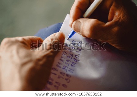 Hand people are writing numbers on paper.