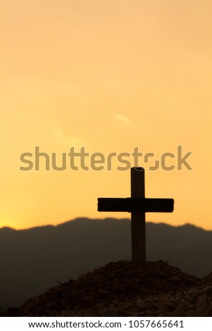 The cross on the mountain has the sunset as the background., Concept for Christian, Christianity, Catholic religion, divine, heavenly, celestial or god.
