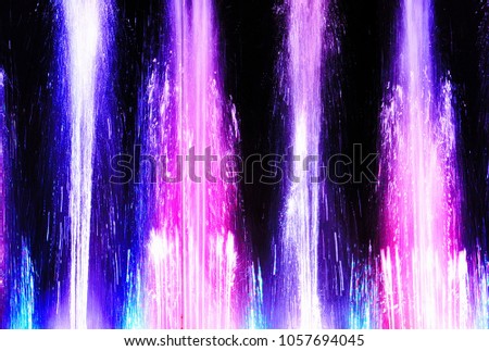 Beautiful abstract vertical background.The picture shows water jets of the fountain with colorful lighting.