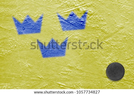 Hockey puck and the image of the Swedish flag on the ice. Concept, hockey