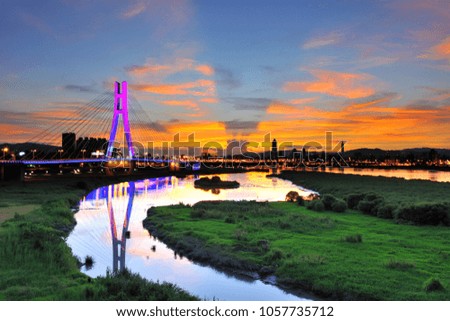 Taipei City's New North Bridge reflects the sunrise sky with colored clouds and ponds before dawn, beautiful views of the bridge and the sleeping city.