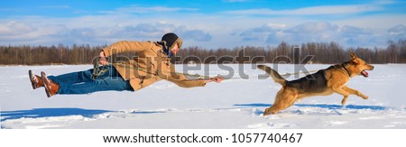 Naughty dog knocked pulls the master off his feet on a leash. not listening orders. The owner and his pet friend are disobedient. dragging a man in the snow behind him. a naughty dog. does not listen.