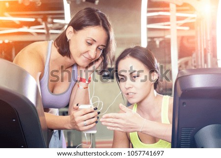 girls in the gym write a message on the phone and have fun