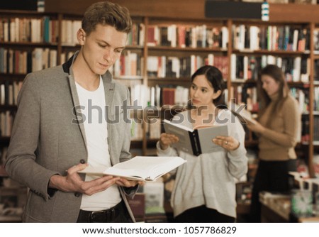 Intelligent man searching for information in books in bookstore
