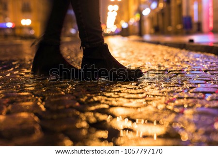 Woman in black shoes walking through the city street