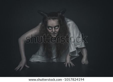 Terrible ghost with horns crawl on dark background