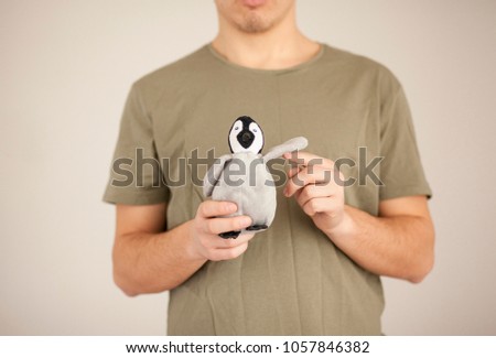 Protection Nature. Male hands, close-up gives, holds protects the symbol, concept, penguin, all animals and mammals. Indifferent people in their palms hands. Irrelevant, frivolous actions in ecosystem