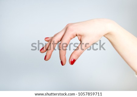 a female hand holds something with her fingers