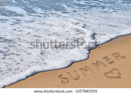 word summer and heart on beach sand