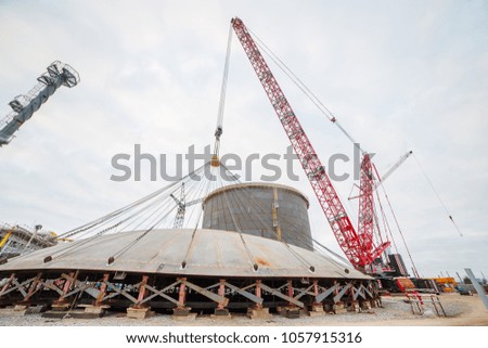Construction of a production hall at a metallurgical plant factory with the help of a tower crane.