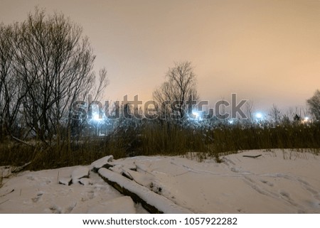 Night photography long exposure. Riga, Latvia industrial port details over frozen river of Daugava