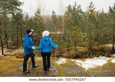 
two women are standing on the path and talking (Nordic walking)