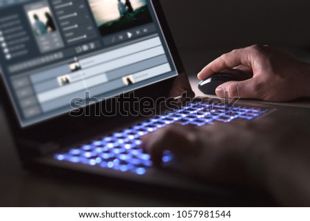 Video editing with laptop. Professional editor adding special effects or color grading footage for commercial film or movie. Man using software in computer. Royalty-Free Stock Photo #1057981544