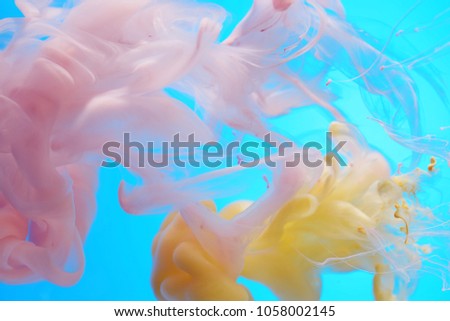 Abstract background of dissolving fluids on a blue background.