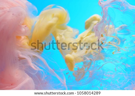 Fluid in dynamic. Abstract color clouds on a sky blue background.