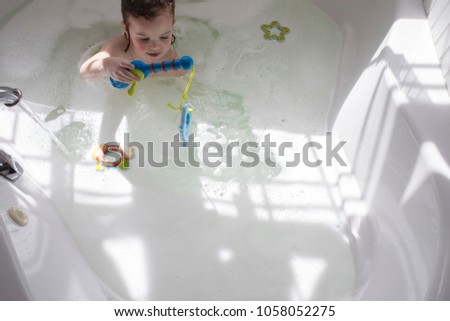 Girl playing with toys in the bath
