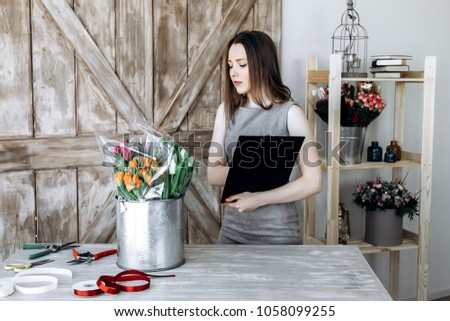 Young girl collects bouquets in a flower shop