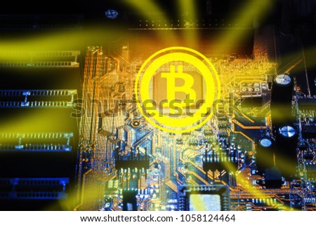 Yellow bitcoin on the background of the electronic circuit of the PC motherboard. Abstract concept of digital currency.