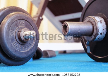 Close up of dumbbell and barbell on the floor at fitness gym