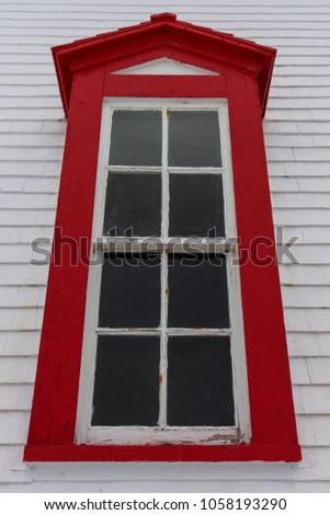 Charming lighthouse window with bright red frame