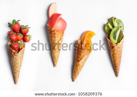 Fruit in waffle cones isolated on white background - healthy ice cream options. Royalty-Free Stock Photo #1058209376