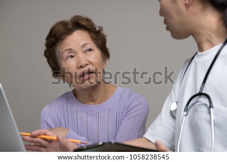 Asian elderly women talking to a doctor