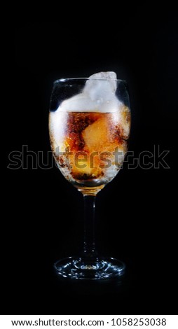 Caramel soft drink poured into a wine glass with ice