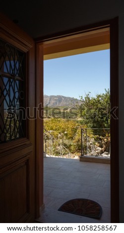 Scenic view of field and mountain from doorway, Crete, Greece