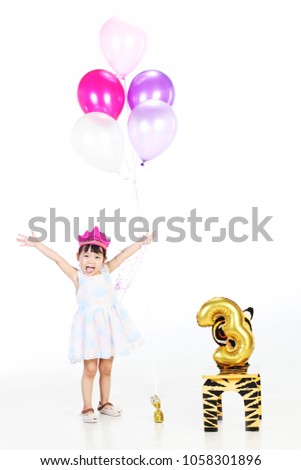 happy asian girl wear blue rainbow dress and her 3rd birthday balloon 
