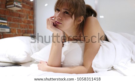 Thinking Positive Young Woman Lying in Bed on Stomach