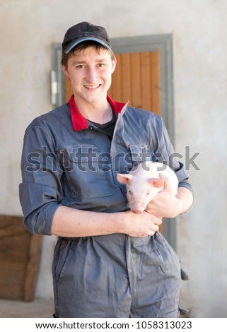 young farmer with young pig agriculture 