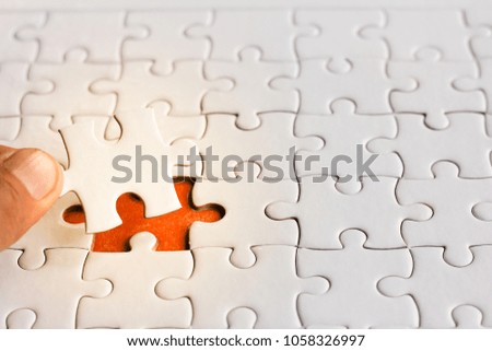 Hand hold the last piece of jigsaw puzzle to complete the mission.,conceptual of problem solving