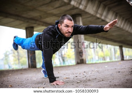 Man working push-ups under bridge. Close up.