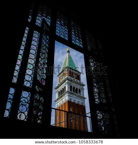 campanile san marco with artistic photo filter for underexposure for richer colors and depth of field shot through a generic window silhouette