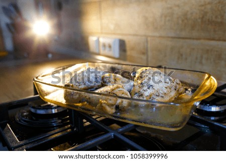 A close up picture of a fresh cooked roasted pieces of chicken just pulling out of the oven on the cooker