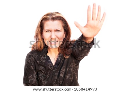 The middle-aged woman pulled her hand forward and yelled at the white background. She is against violence. She is dressed in a black shirt. Isolated