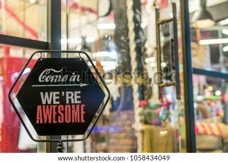 Open sign in the retail store. Bali island. Text come in we are awesome.